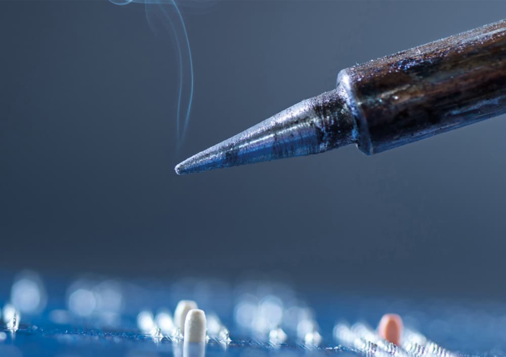 Dampfender Loetkolben ueber Mikrochip