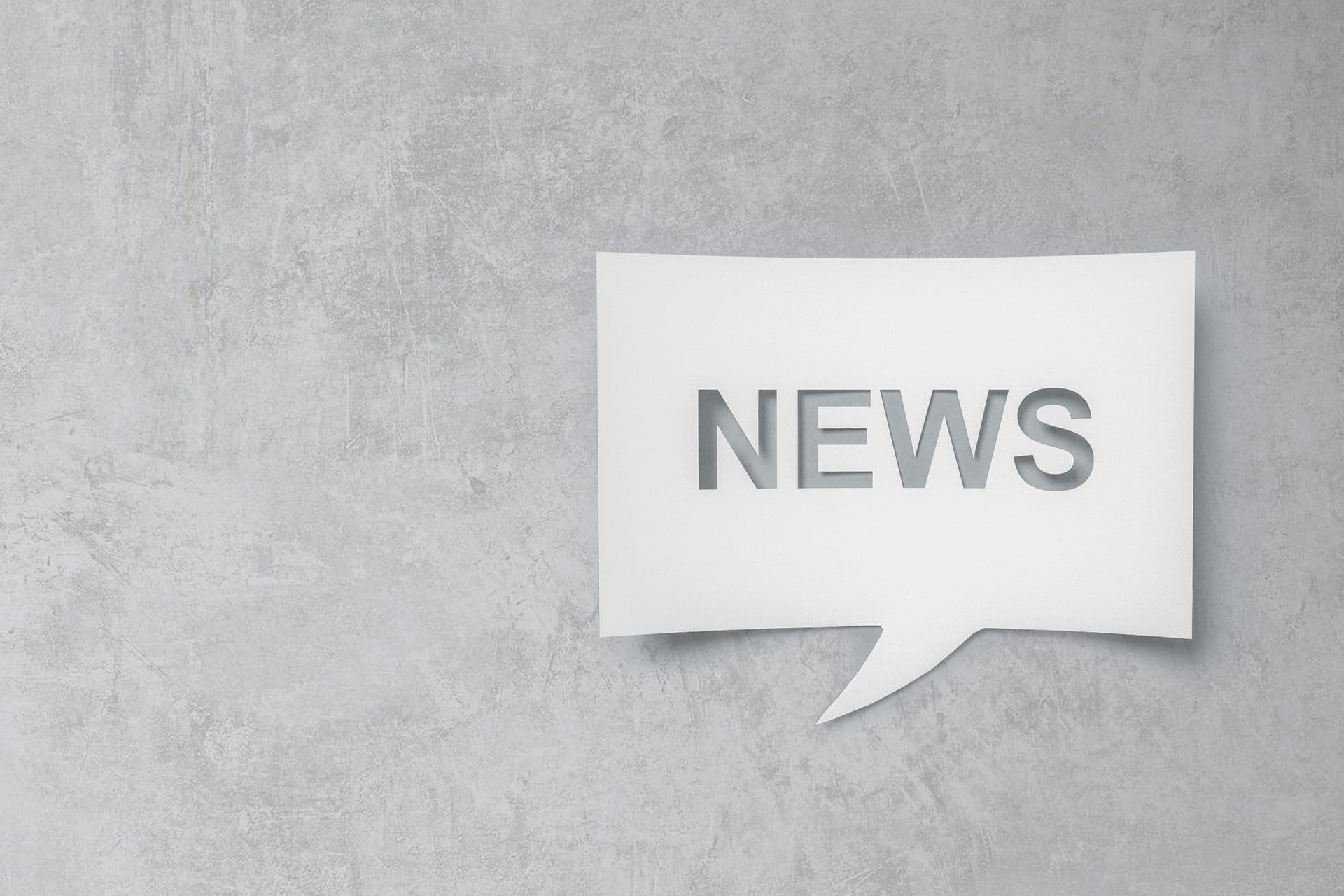 Sprechblase mit dem Titel "News" auf grauen Betongrund