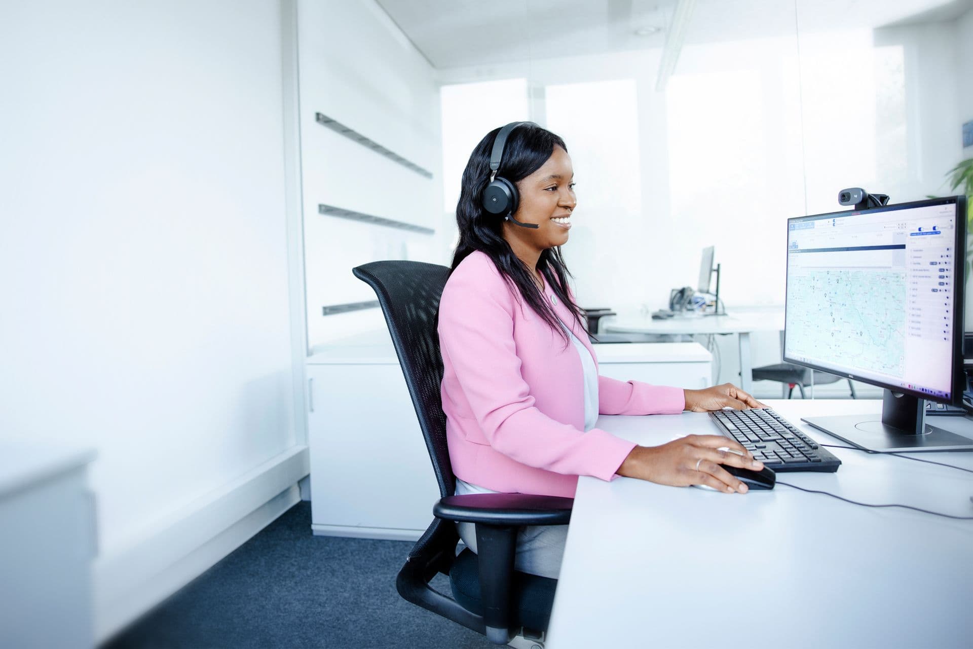 Eine Boge Mitarbeiterin sitzt in einem weißen Büro und telefoniert mit einem Kunden