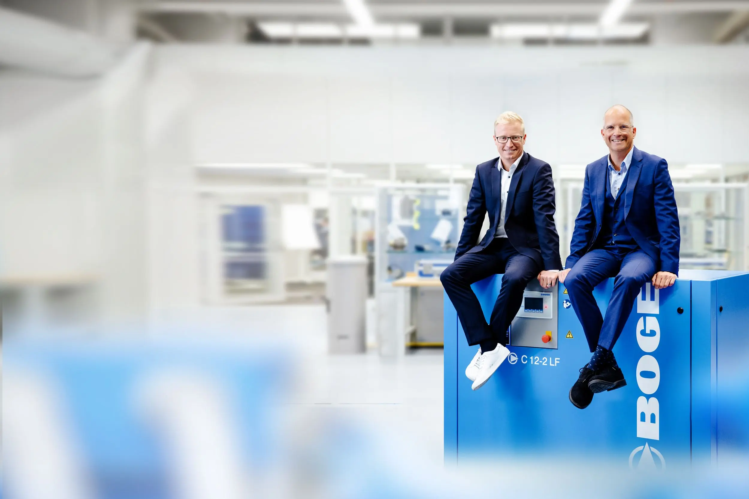 Das Duo der Geschäftsfuehrung sitzt auf einem Kompressor der C-Baureihe